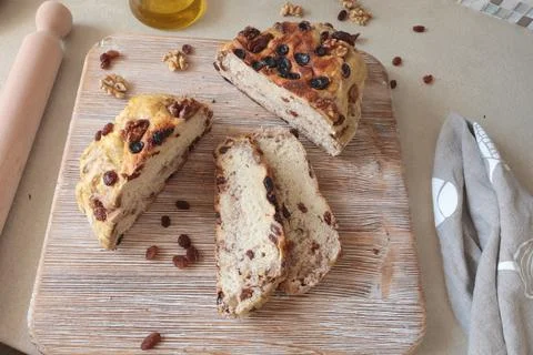 Homemade bread on wooden board with walnuts and raisins. Food and organic Stock Photos