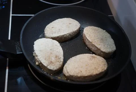 Homemade breaded cutlets are fried in a frying pan. Stock Photos