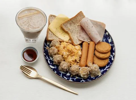 Homemade breakfast is including Breads, Fried sausages, Ham, Pork shumais. Stock Photos