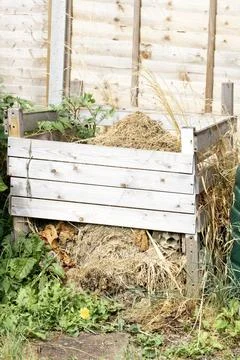 Homemade built compost patch bin with dried out cuttings and grass Stock Photos