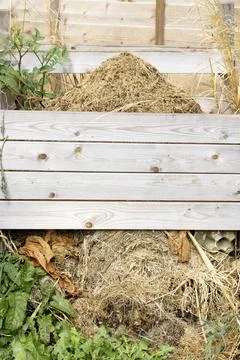 Homemade built compost patch bin with dried out cuttings and grass Stock Photos