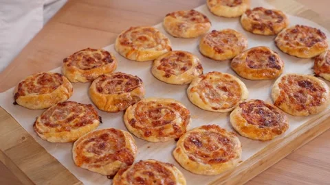 Homemade buns in the shape of snails with ham and cheese on a wooden board. Stock Footage 264141753