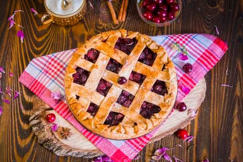 Homemade cherry pie on rustic background. Cake on a kitchen towel on a wooden Stock Photos