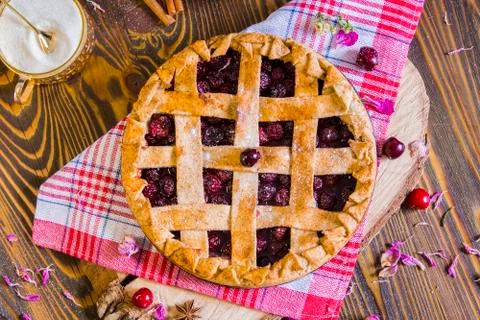Homemade cherry pie on rustic background. Cake on a kitchen towel on a wooden Stock Photos
