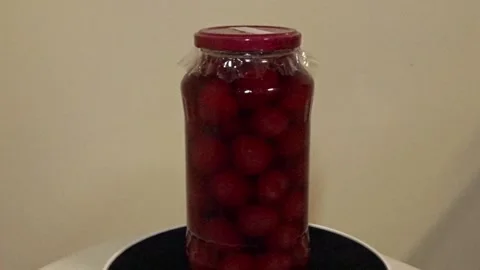 Homemade cherry preserves rotating slowly in glass jar Stock Footage 336722951