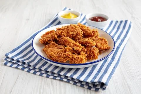 Homemade Chicken Strips with Mustard and BBQ on a Plate, side view. Stock Photos