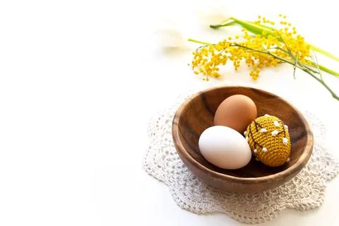 Homemade colored crocheted Easter eggs. Easter holiday banner with tulips and Stock Photos