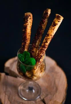 Homemade crispy breadsticks or grissini with squid, spices and fresh basil Stock Photos