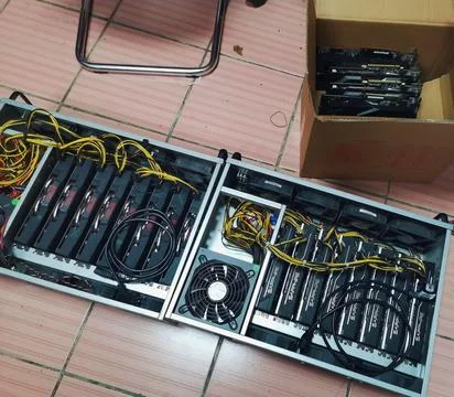 A homemade cryptocurrency mining rig assembly resting on a tiled floor, Stock Photos