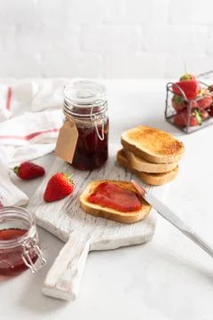 Homemade delicious strawberry jam with toasts and fresh strawberry on a rusti Stock Photos