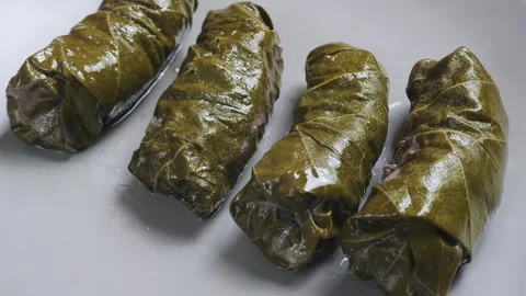 Homemade dolma with beef rotates in a circle on a gray plate. Close-up. Vidéo 299397902