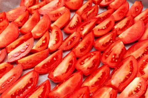 Homemade dried red  tomatoes slices with basil oregano spices cooking process Stock Photos