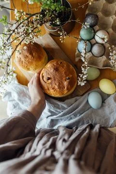 Homemade easter bread in hands on background of natural dyed eggs and sprin.. Stock Photos