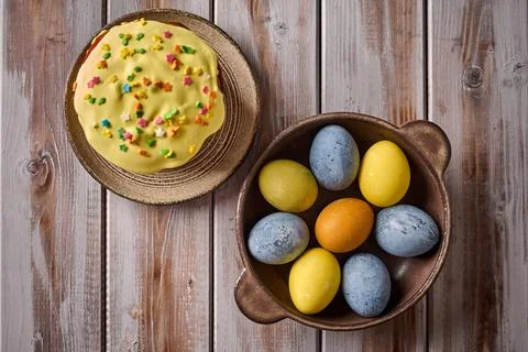 Homemade Easter cake and multi-colored painted eggs on black platter Stock Photos