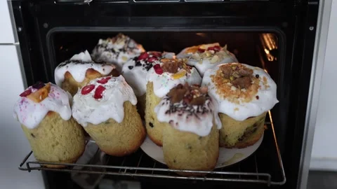 Homemade Easter cakes baking in oven sweet bread with fluffy icing colorful topp Stock Footage 307142757