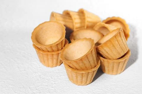 Homemade empty tartlets baskets of puff pastry, on a white background Foto stock