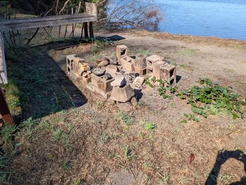 Homemade firepit built with cinder blocks and a rustic wooden bench Photos