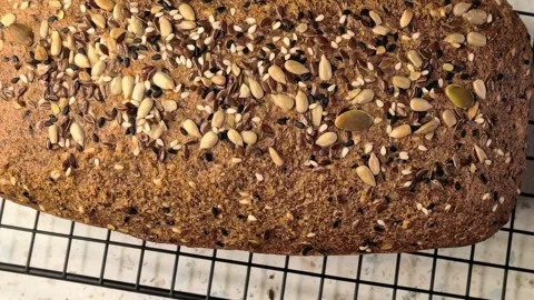 Homemade fresh baked bread loaf topped with mixed seeds, healthy rustic baking Stock Footage 342497018