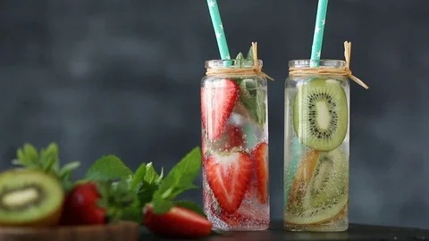 Homemade fruit water with kiwi and strawberry in jar, healthy food concept Stock Footage