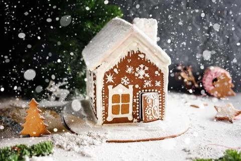 Homemade gingerbread house, falling snow and festive Christmas decorations. Stock Photos