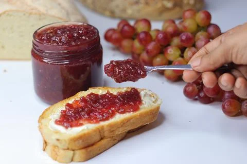 Homemade Grape Jam Spread on Bread with Fresh Grapes Foto stock