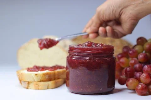 Homemade Grape Jam Spread on Bread with Fresh Grapes Foto stock