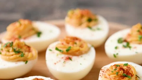 Homemade hard Boiled Deviled Eggs garnished with herbs 스톡 동영상 319531172