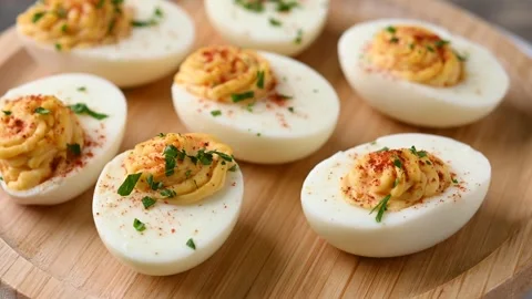 Homemade hard Boiled Deviled Eggs garnished with herbs Video stock 319531197