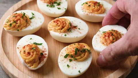 Homemade hard Boiled Deviled Eggs garnished with herbs Video stock 319652975
