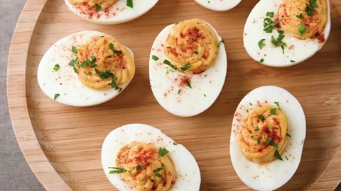 Homemade hard Boiled Deviled Eggs garnished with herbs Video stock 319653035