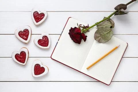 Homemade heart shaped cookies with empty notebook frame, pencil and red rose Stock Photos