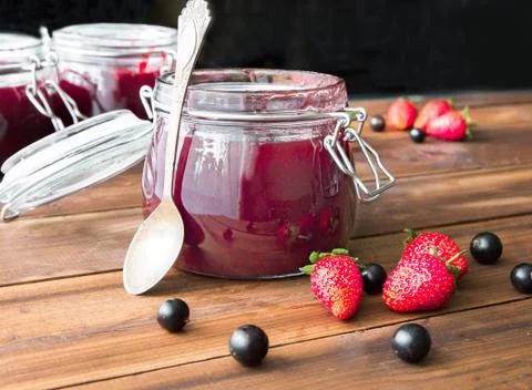 Homemade jam with berries and spoon on the wooden table Stock Photos