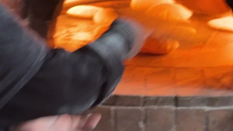 Homemade method of Arabic bread in Egypt being placed in the oven. Stock Footage 300134379