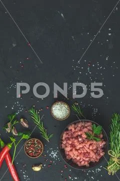 Homemade minced meat in a black bowl with ingredients for making Stock Photos