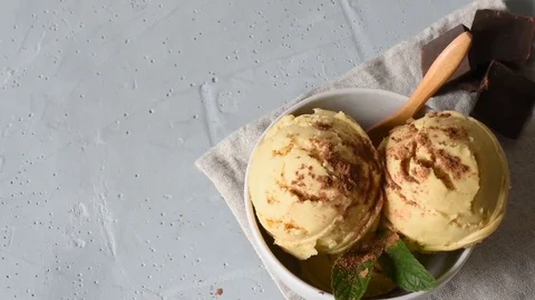 Homemade organic vanilla ice cream on a light background sprinkled with grated Stock Footage