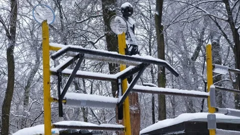 Homemade outdoor pull-up bars and a boxing mannequin in a helmet covered Stock Footage 327533439