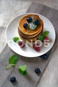 Homemade pancakes with forest fruits berries on white table. Fresh pancakes o Stock Photos