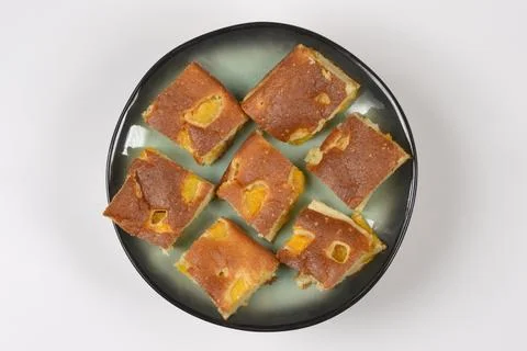 Homemade peach sponge cake squares on a plate Stock Photos