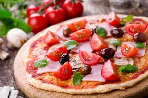 Homemade pizza with fresh tomatoes olives and mushrooms Stock Photos