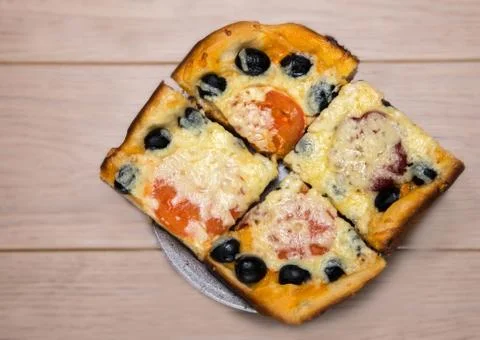 Homemade pizza with ham cheese olives tomatoes on wooden table Stock Photos