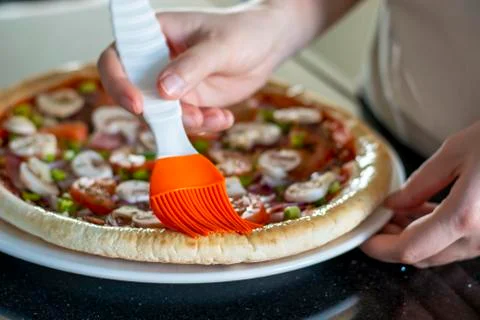 Homemade pizza with vegetables. The process of making pizza at home. Hands of Stock Photos
