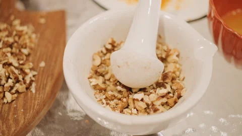 Homemade pumpkin pie preparation. Rustic kitchen setting with nut grinding. Home 動画素材 346405071