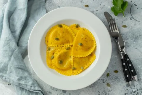 Homemade Pumpkin Ravioli with butter on a light concrete background. Top view Stock Photos
