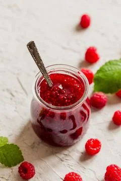 Homemade raspberry jam on a concrete background with fresh raspberries, sel.. Stock Photos