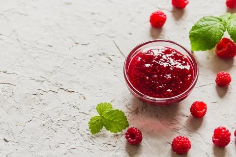 Homemade raspberry jam on a concrete background with fresh raspberries, sel.. Stock Photos
