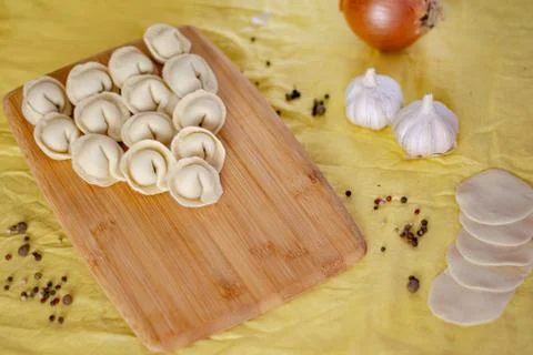 Homemade raw dumplings on a wooden board. Home cooking concept. Stock Photos