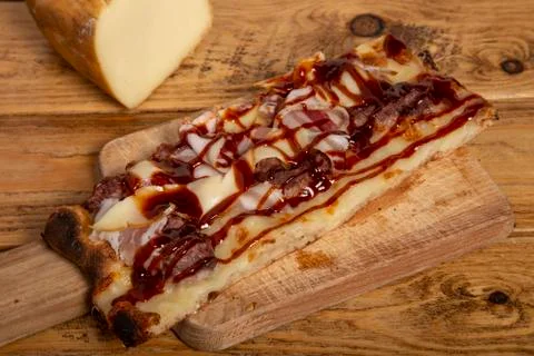 Homemade rectangular bacon pizza with barbecue sauce on wooden rustic wooden  Stock Photos