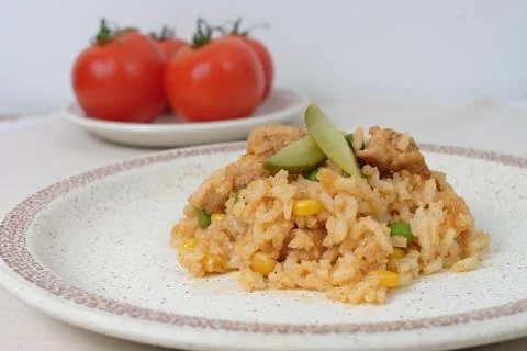 Homemade risotto with corn, peas and chicken on a plate on the table Stock Photos