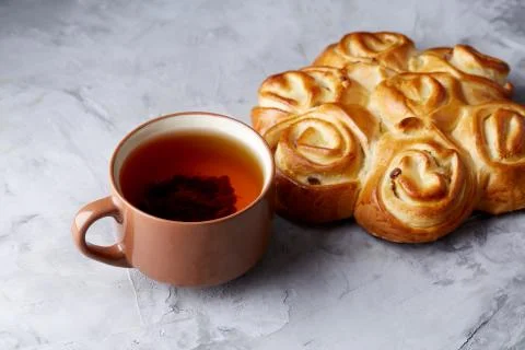 Homemade rose bread, cup of tea, dried citrus and spicies on white textured Stock Photos