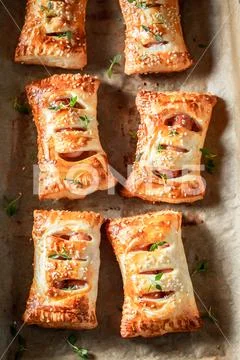 Homemade sausage in puff pastry with thyme and sesame seeds Stock Photos